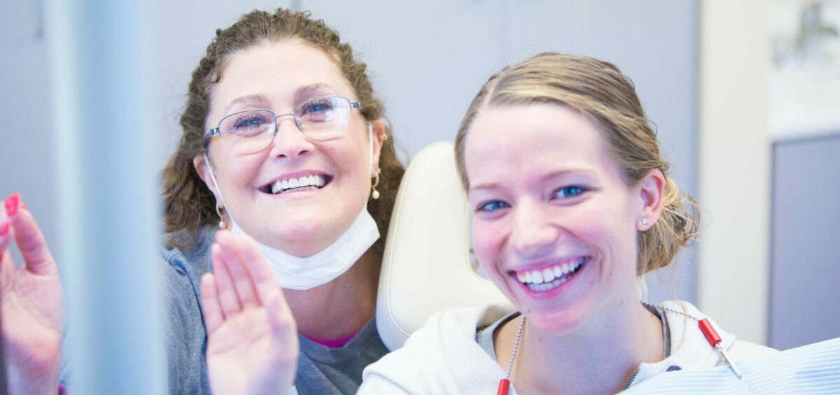 a person smiling next to another woman